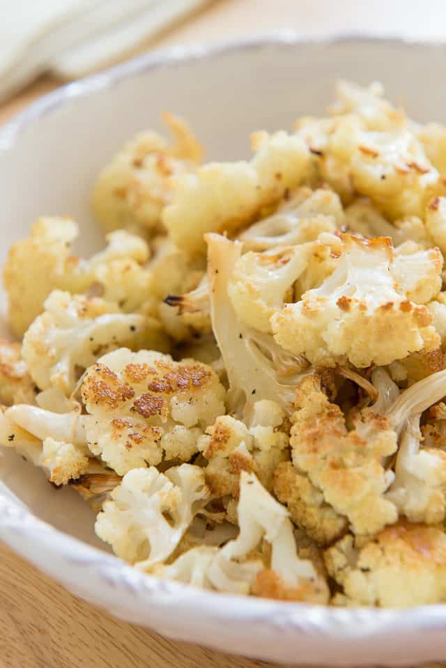 Roasted Cauliflower Recipe Plated in a White Bowl on Wooden Board