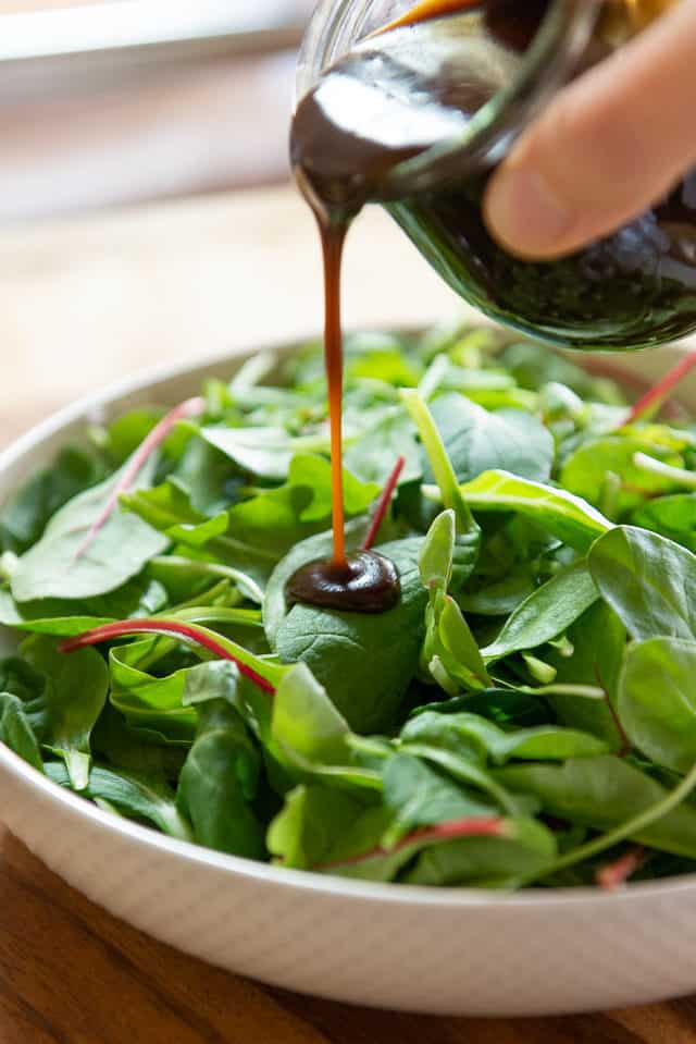 Balsamic Vinaigrette Recipe - Pouring Over Salad Greens In Bowl