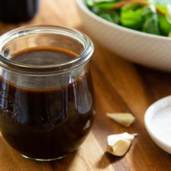 Balsamic Vinaigrette In Glass Jar with Salad in Background