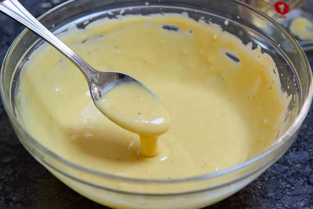 Caesar Dressing Recipe - In Glass Bowl with Spoon Showing Thick Texture