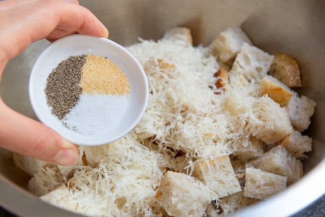 Adding Spices and Seasoning to Parmesan Croutons in Bowl
