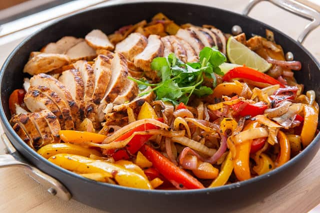 Chicken Fajitas Recipe - Served in Skillet with Vegetables and Sliced Meat