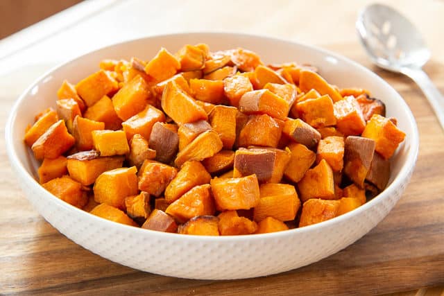 Roasted Sweet Potato Chunks - in White Bowl on Wooden Board