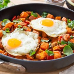 Sweet Potato Hash In a Skillet with Fried Eggs On Top