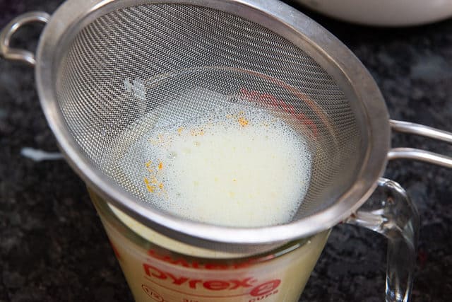 Straining the crème brûlée liquid through strainer 