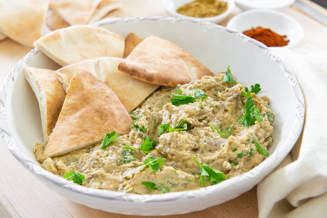 Baba Ganoush Recipe - Presented in White Bowl with Pita and Tahini, Olive Oil, and Spices