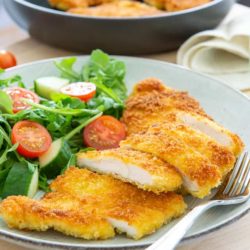 Chicken Milanese Sliced and Served on Plate with Salad