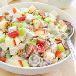 Waldorf Chicken Salad In a White Bowl With Grapes, Pecans, Apples, Celery, and a Mayonnaise Dressing