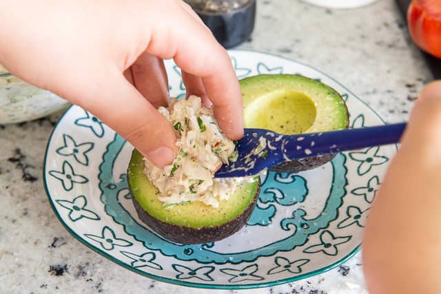 Spooning Crab Salad into Avocado Half