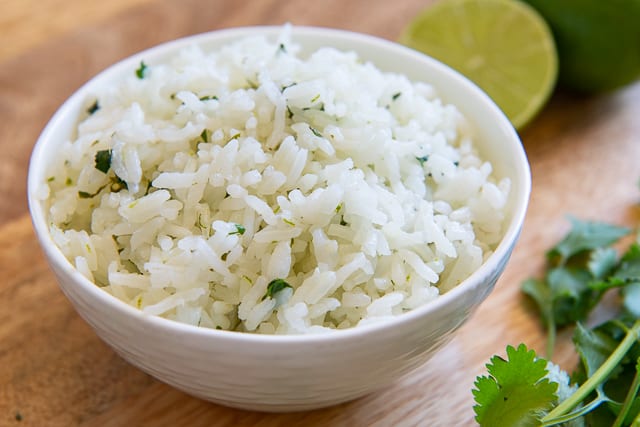 Lime and Cilantro Rice - In a Bowl with Fresh Lime and Cilantro Around