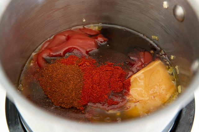 Ketchup, Molasses, Honey, Chipotle Chile Powder, Smoked Paprika, and More Ingredients Added to Saucepan