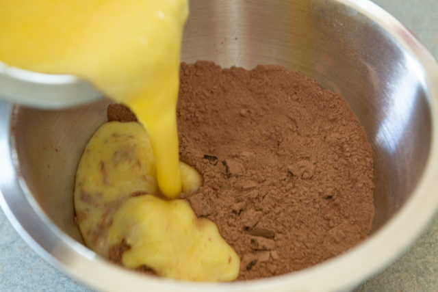 Pouring Buttermilk Egg Liquid Into Cocoa Dry Ingredients in Mixing Bowl