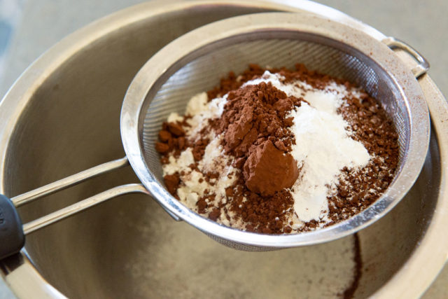 Sifting Together the Dry Ingredients with Fine Mesh Strainer, with Cocoa Powder and Flour