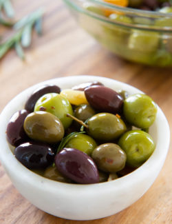 Marinated Olives - In a White Bowl on a Wooden Board