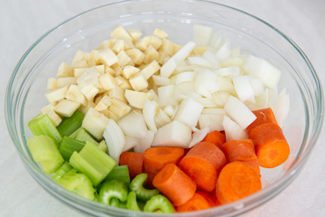 Cut Carrots, Celery, Chopped Onion, and Diced Parsnips in Glass Bowl