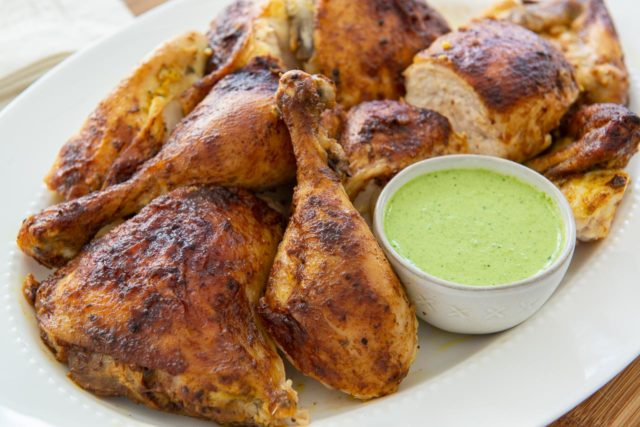 Peruvian Chicken Recipe - Plated on White Dish with Bowl of Green Sauce