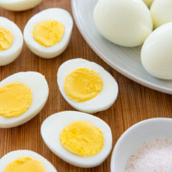 Hard Boiled Eggs Sliced on a Wooden Board