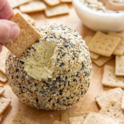 Everything Bagel Cheese Ball Recipe with Crackers on Wooden Board