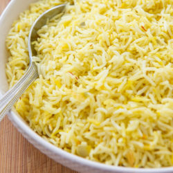 Saffron Rice in a White Bowl with Serving Spoon