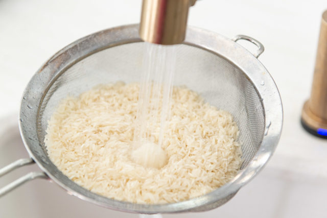Rinsing Basmati Rice in a Fine Mesh Strainer Under Running Water