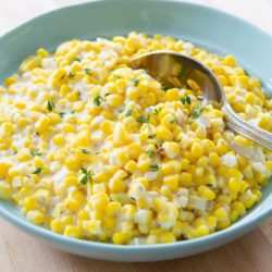 Creamed Corn in a Blue Bowl with Serving Spoon