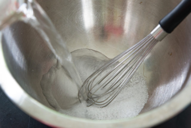 Whisking together salt and water in a bowl