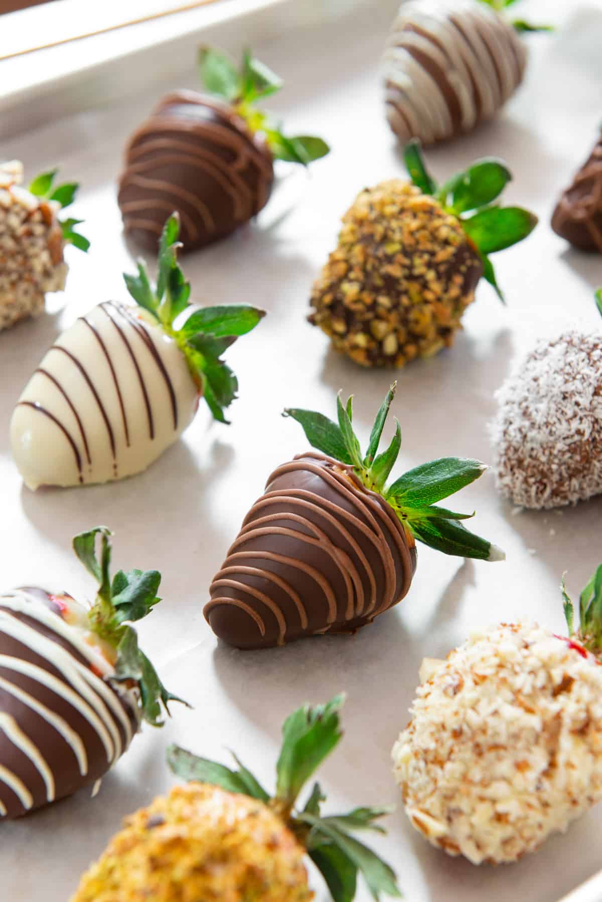 Chocolate Covered Strawberries On a Piece of Wax Paper with Various Chocolate Dips and Drizzles