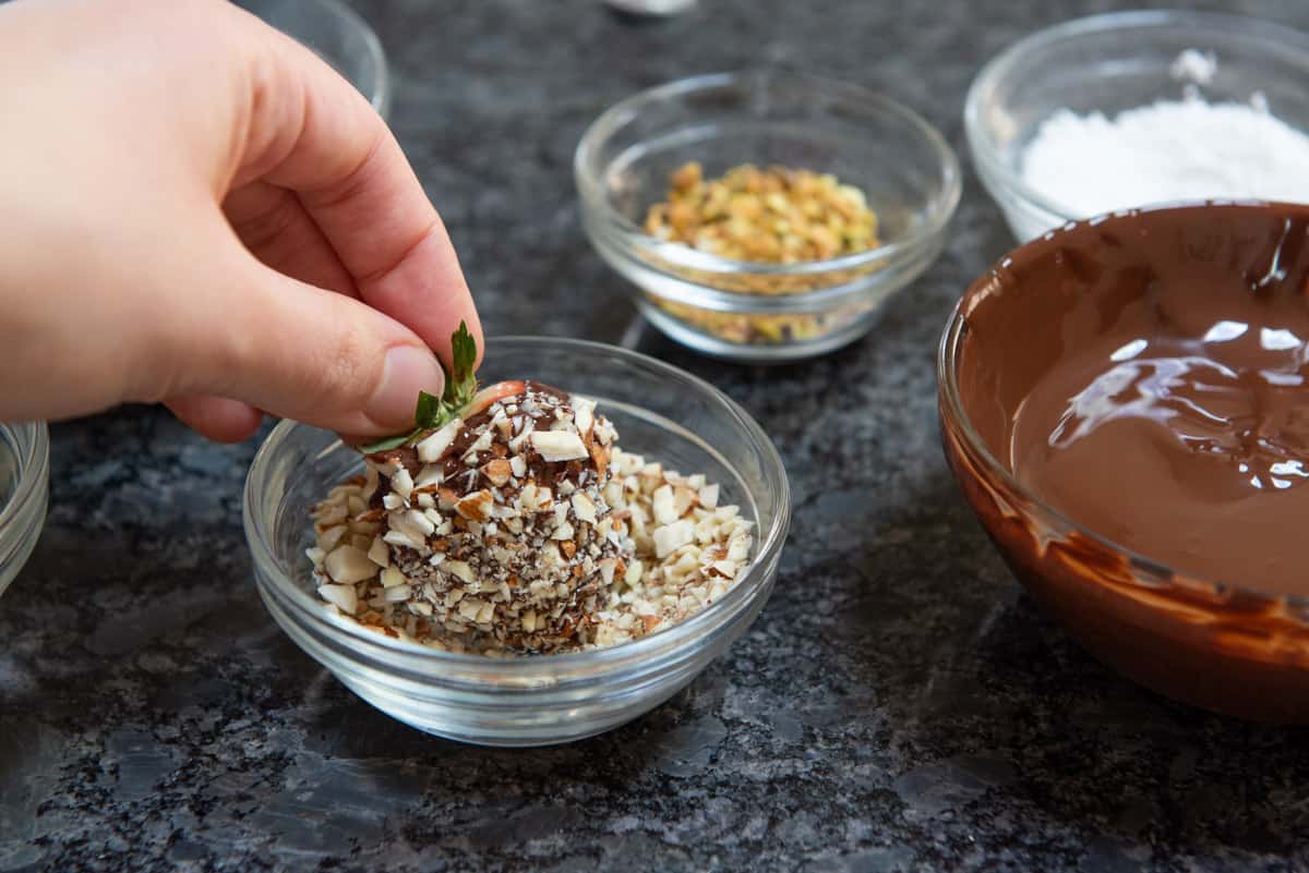 Dipping Chocolate Strawberry Into Chopped Nuts
