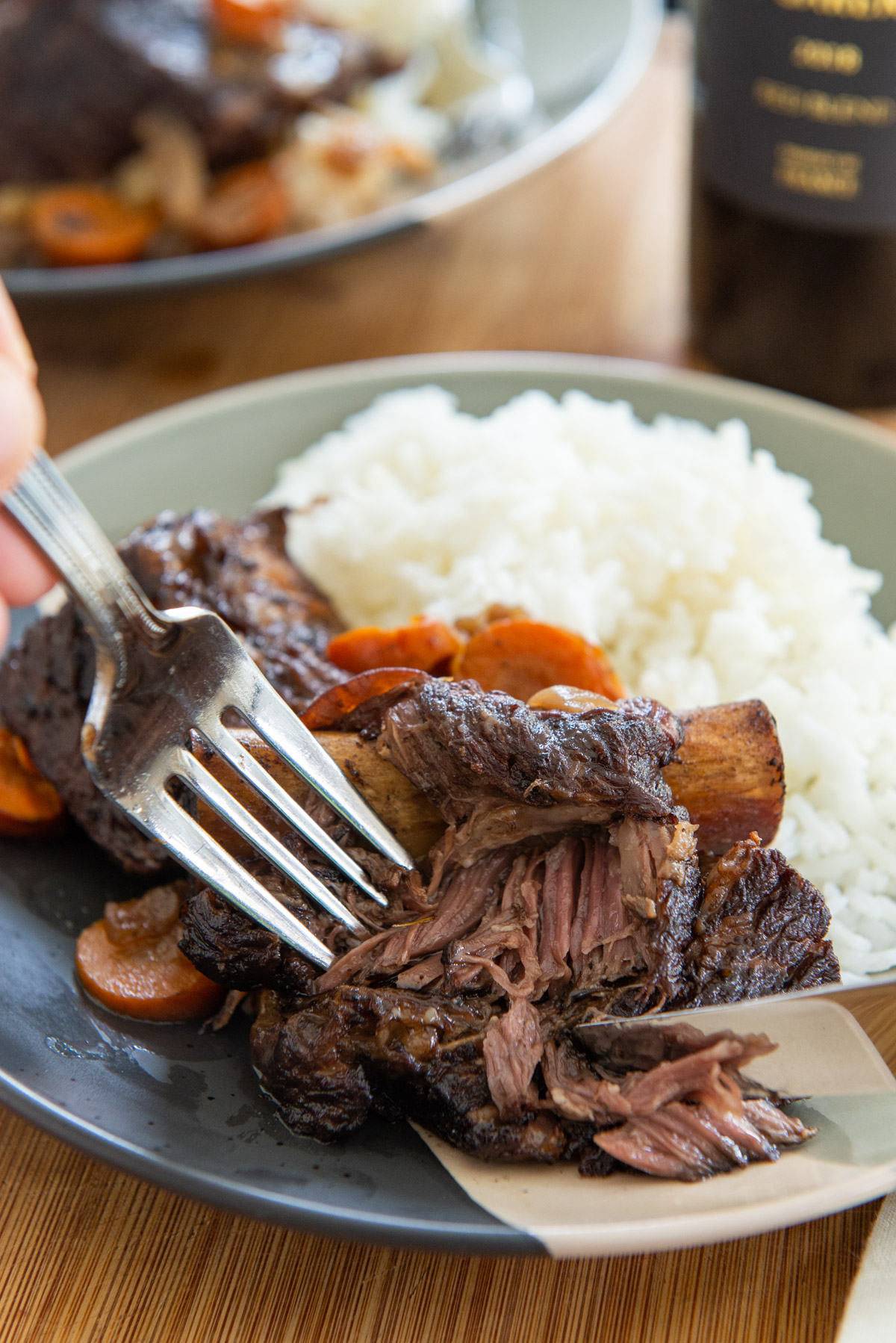 Slow Cooker Short Ribs Plated with White Rice and Fork and Knife Showing Texture