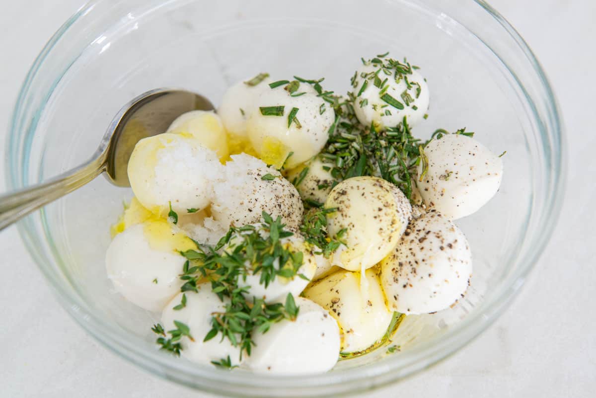 Fresh Mozzarella Balls in a Bowl with Herbs and Olive Oil
