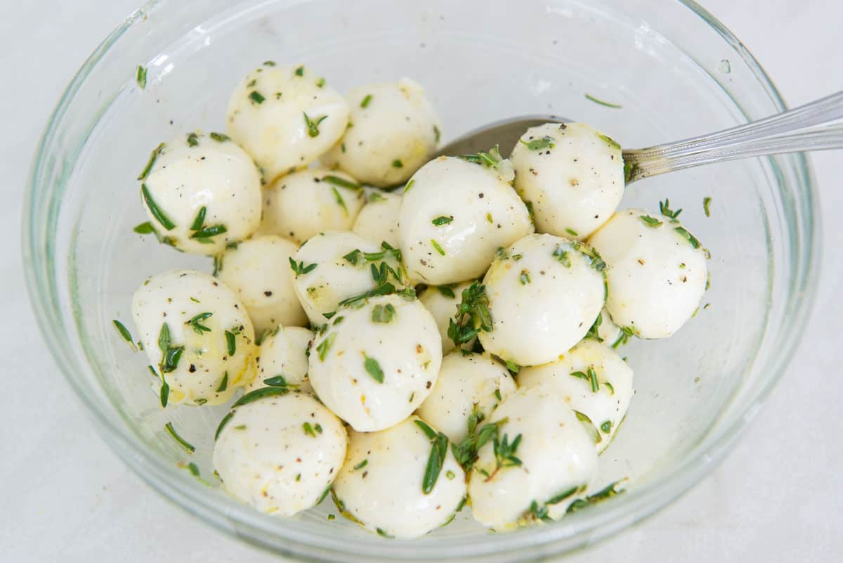 Fresh Ciligiene Mozzarella Balls in a Bowl with Herbs and Olive Oil