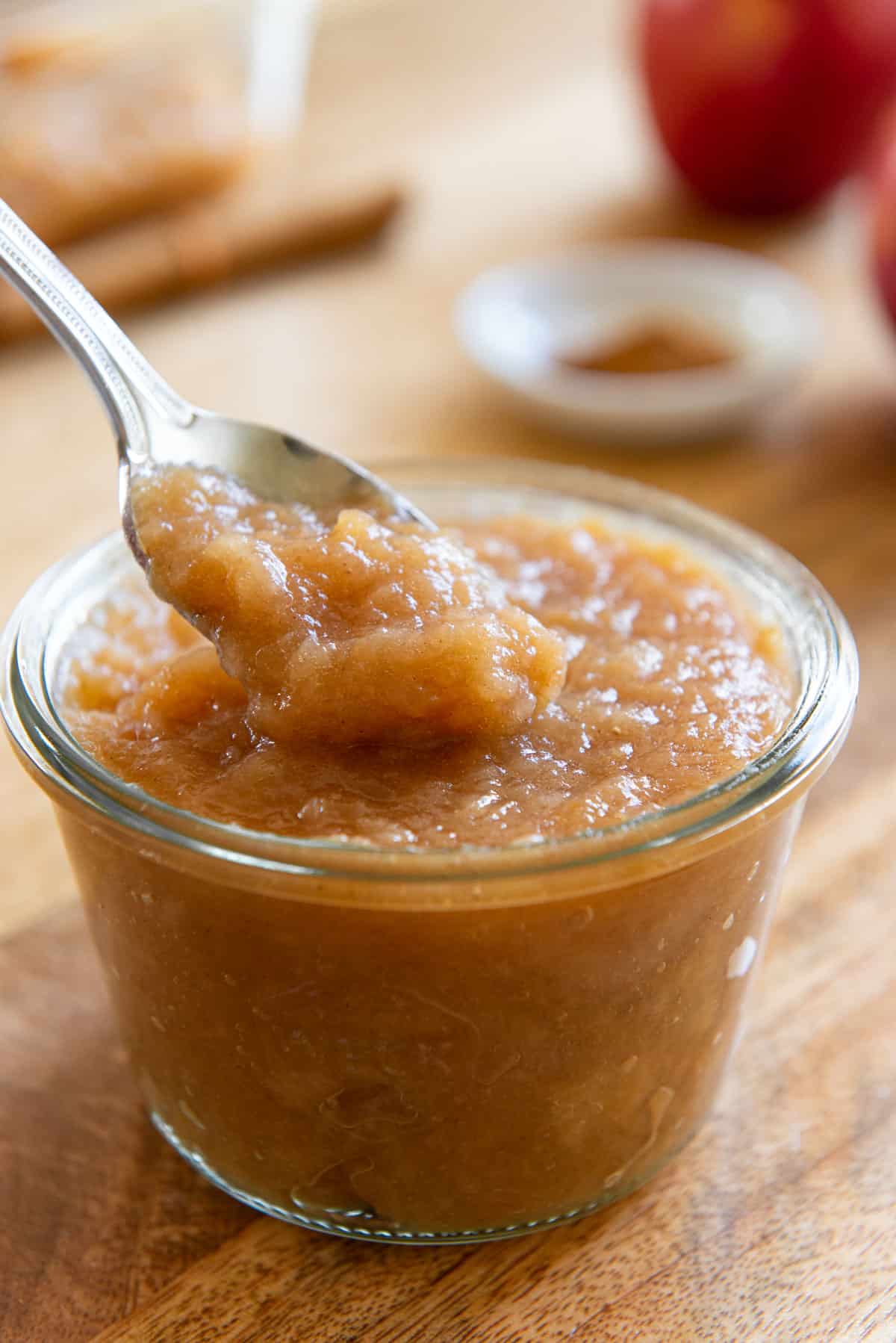 Crockpot Applesauce Served in a Glass Jar with Spoonful 