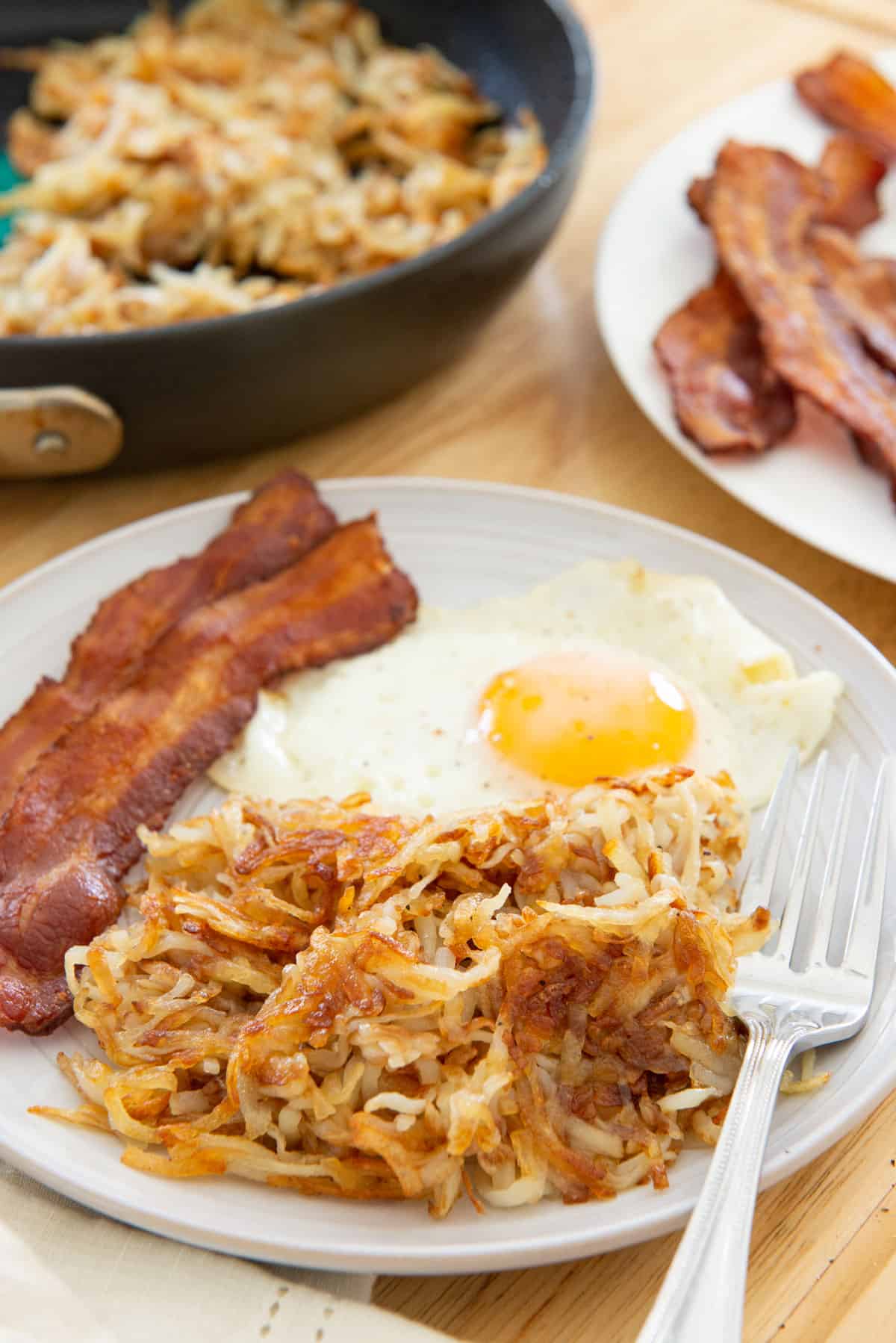 Hash Browns On a Plate With Egg and Oven Bacon