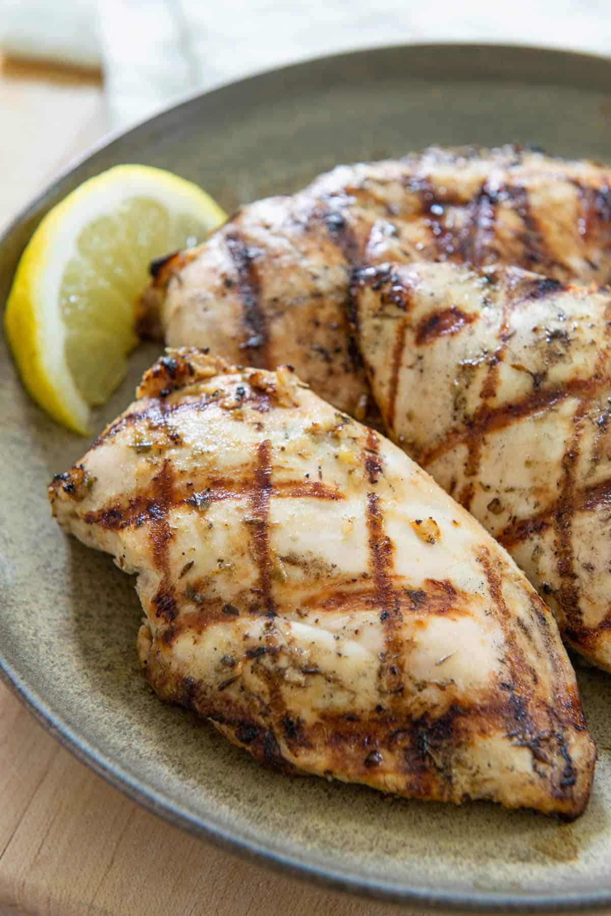 Three Pieces of Grilled Chicken on a Plate with Lemon