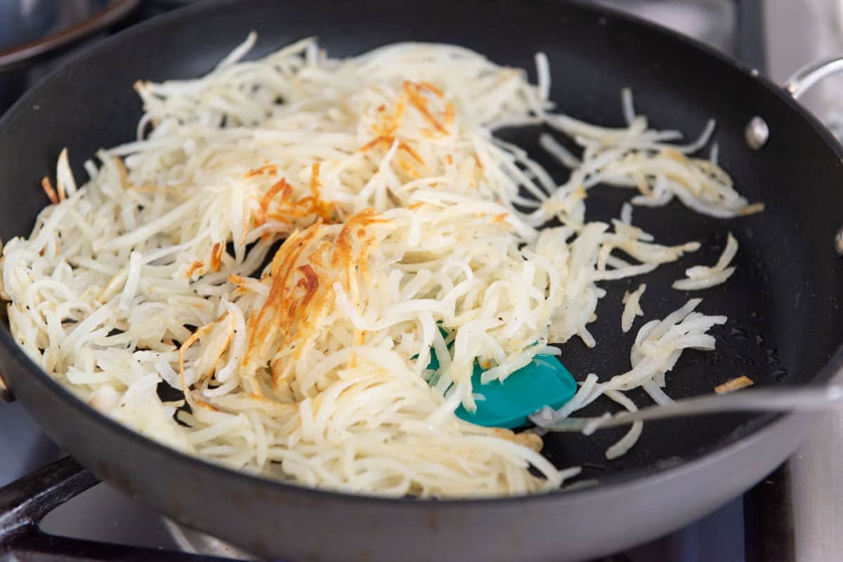 Shredded Potatoes in a Skillet Partially Browned