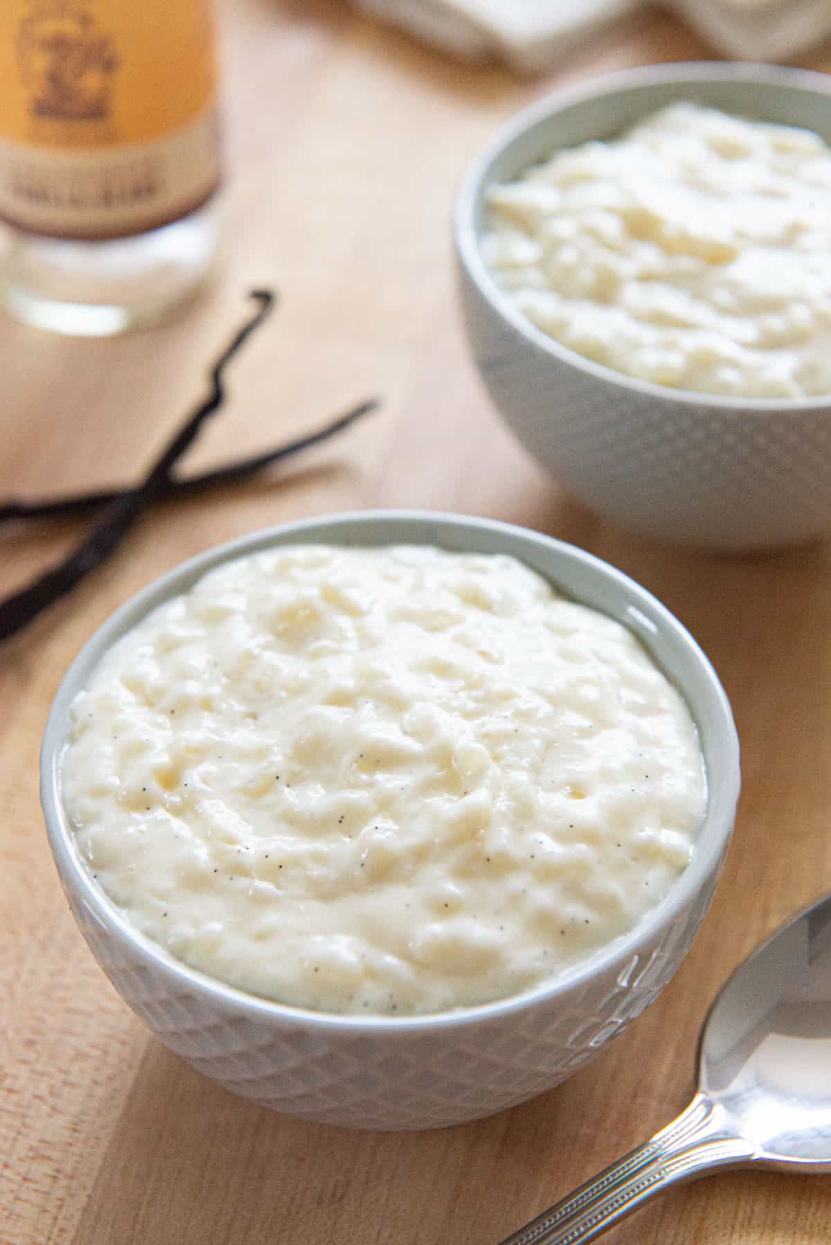 Rice Pudding In a Small Blue Bowl with Vanilla Pods