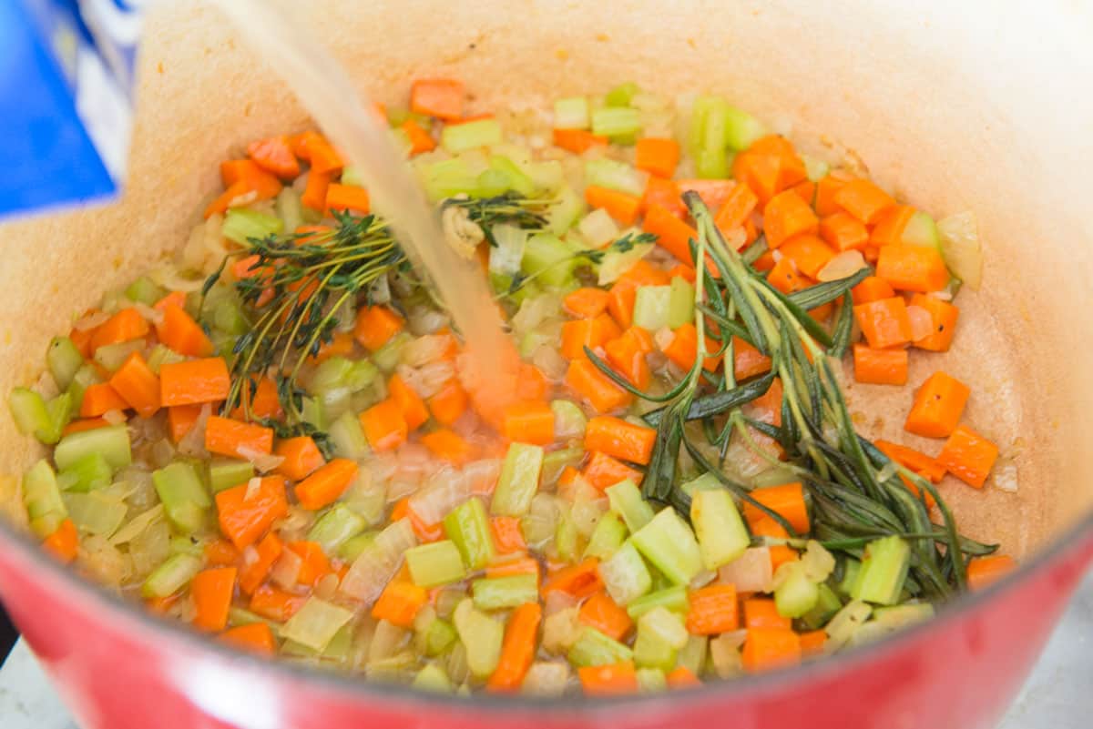 Pouring Broth Into Pot with Cooked Vegetables