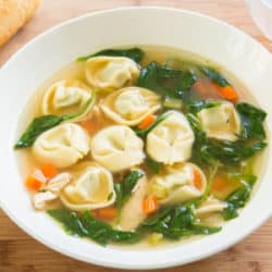 Chicken Spinach Tortellini Soup in Bowl on Wooden Surface