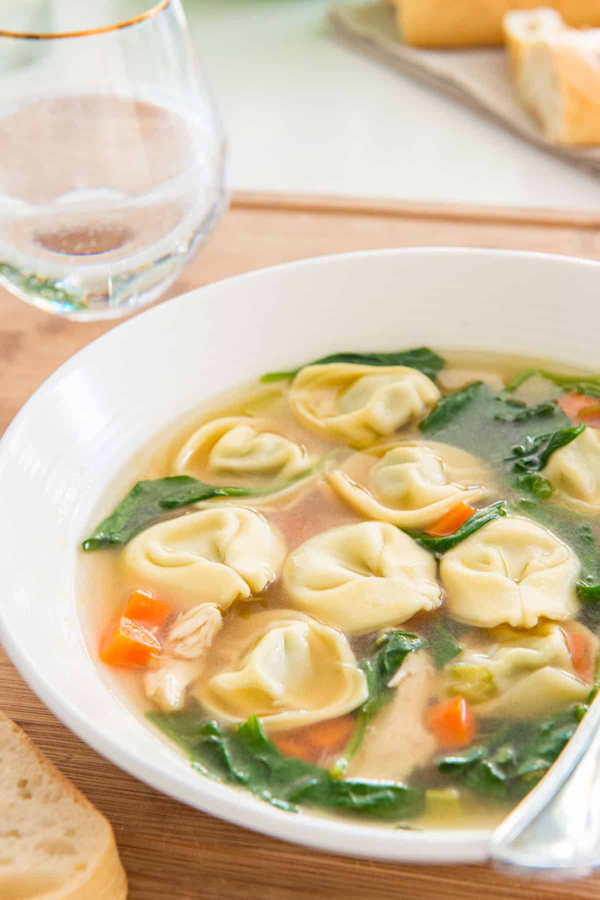 Chicken Soup with Tortellini and Spinach in Bowl