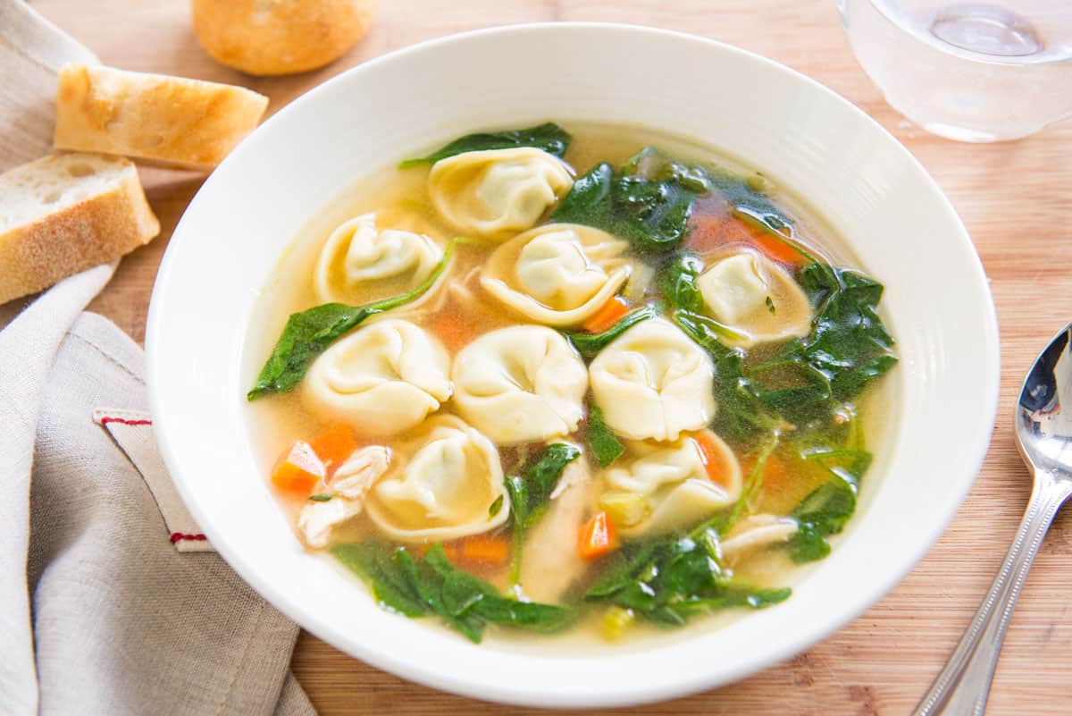 Chicken Spinach Tortellini Soup in White Bowl with Bread