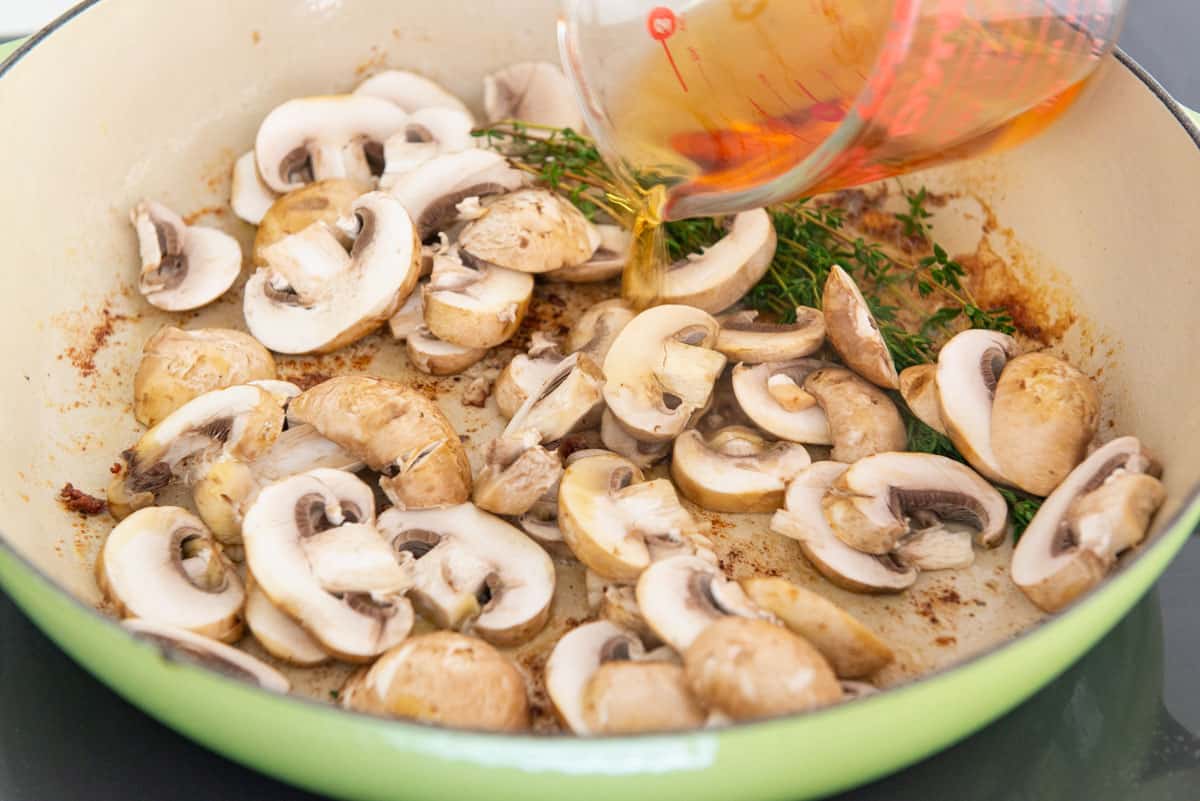 Sliced Mushrooms, Thyme, and Marsala Wine Added to Green Pan