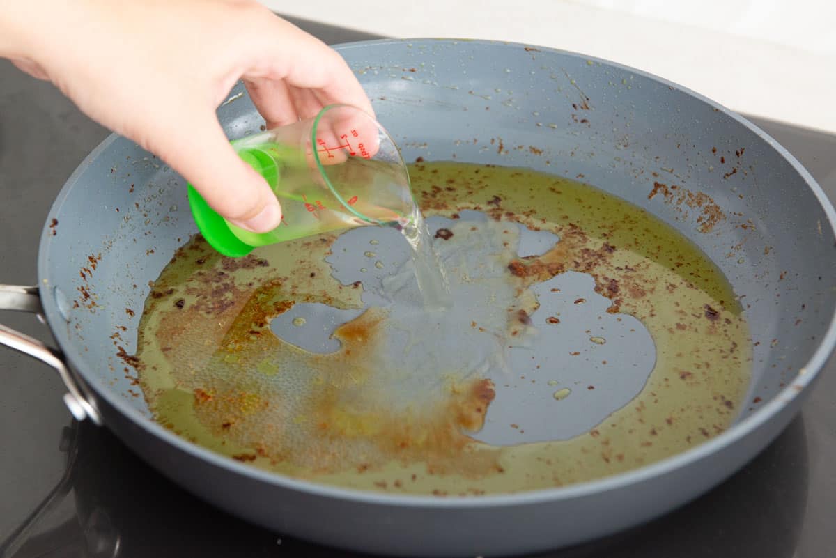Pouring White Wine Into Skillet for Reducing