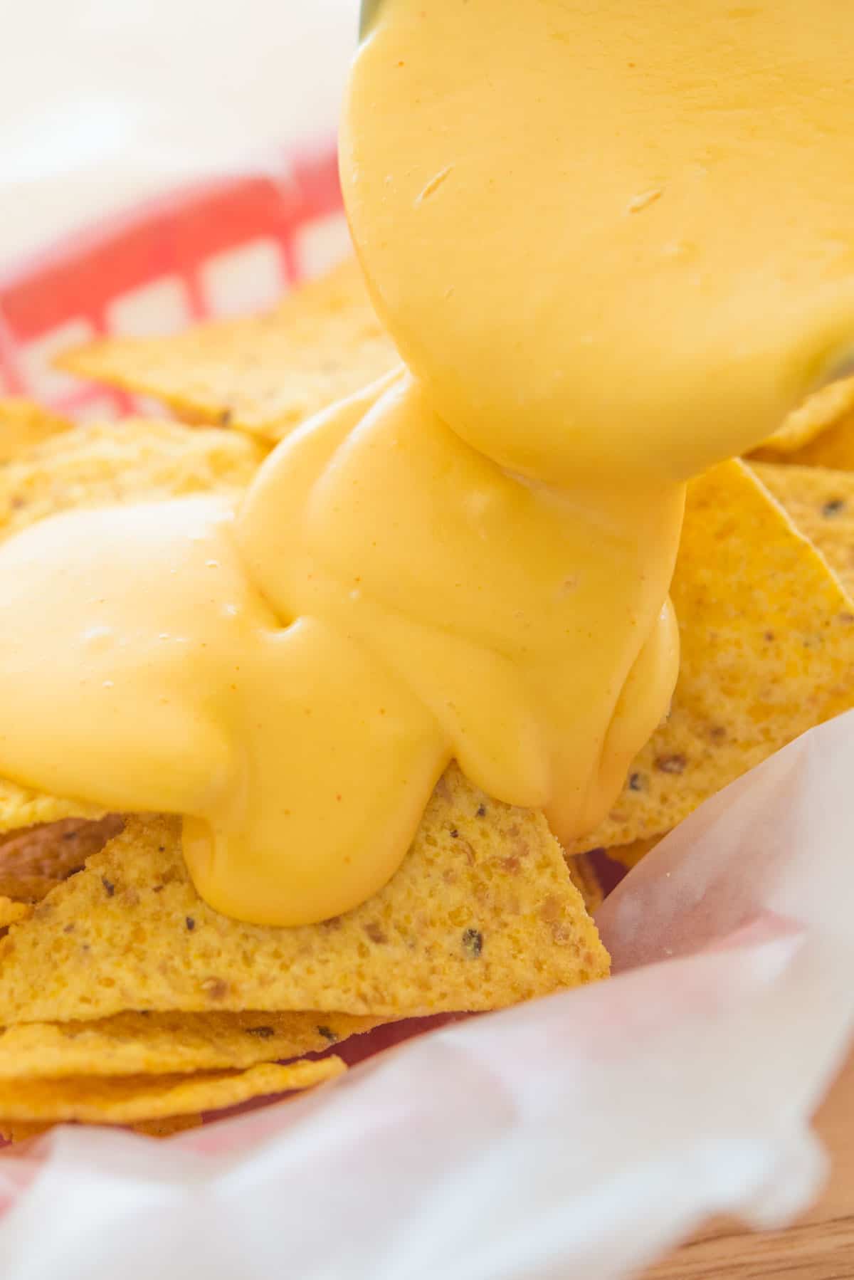 Nacho Cheese Sauce Drizzled Over Chips