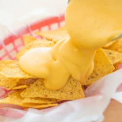 Nacho Cheese Sauce Ladled Over Chips