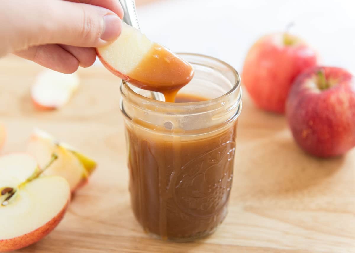 Caramel Recipe Served in a Glass Jar with Apple Slice Dipped In