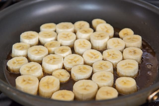 Banana slices in skillet with honey mixture