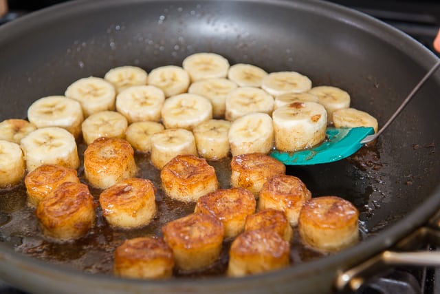 Flipping over the banana slices as they become caramelized