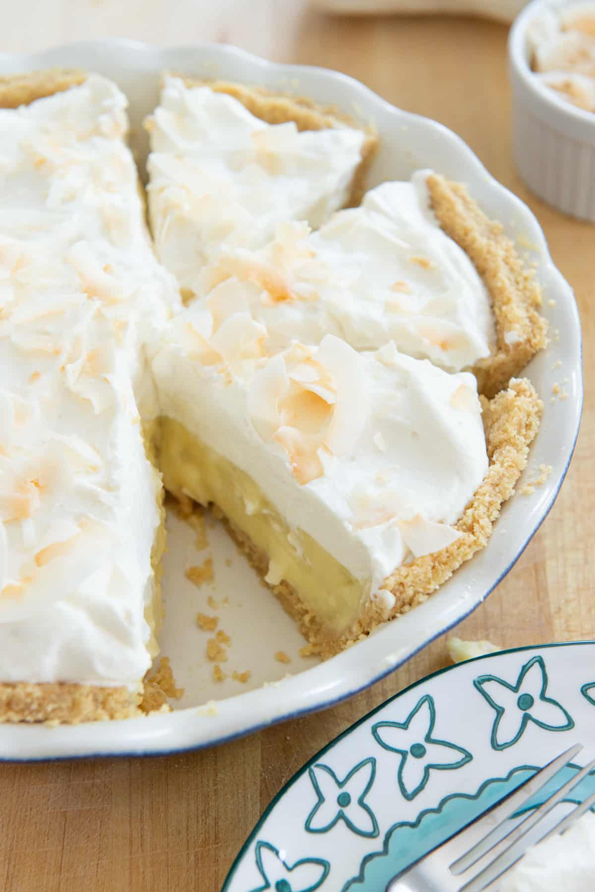 Freshly made coconut cream pie in a pie plate with slices cut