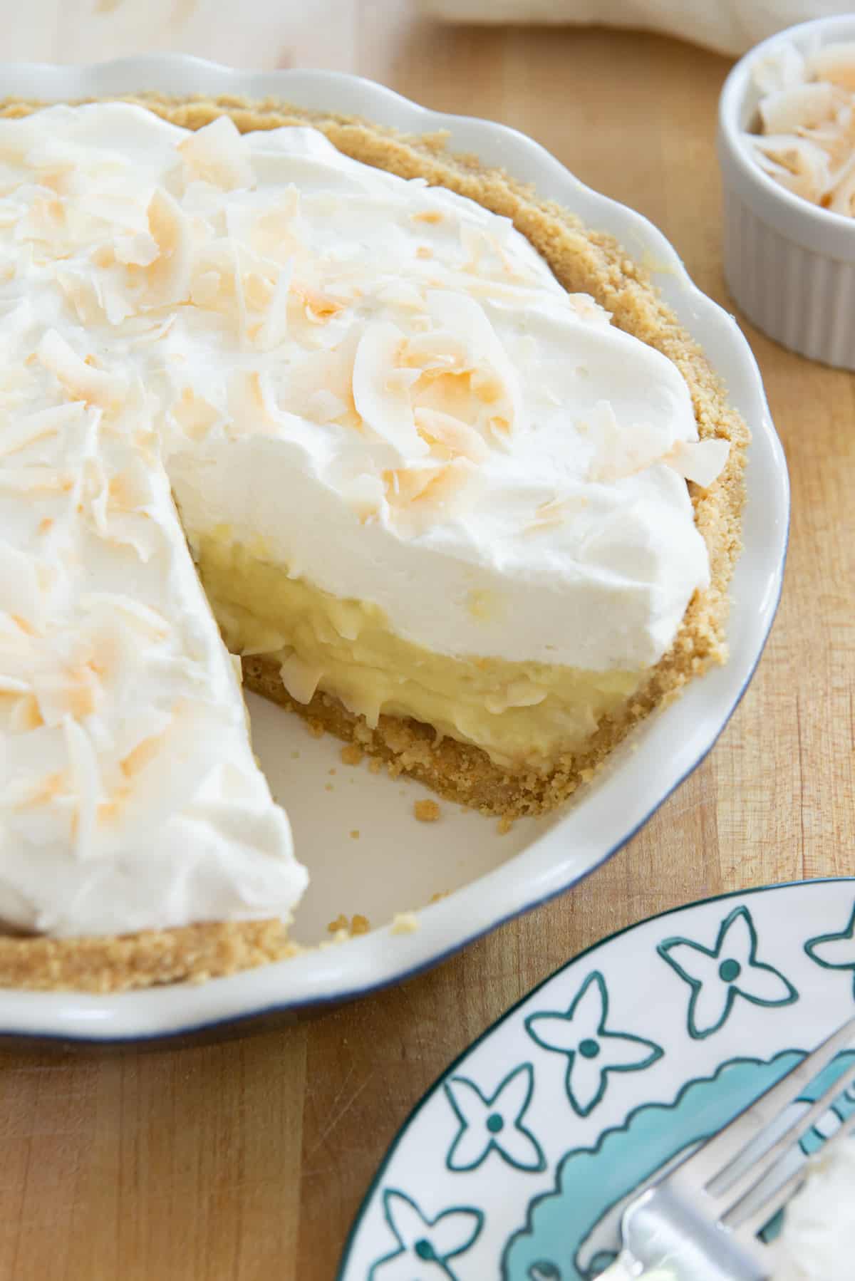 Fresh Coconut Cream Pie with a slice removed onto a plate