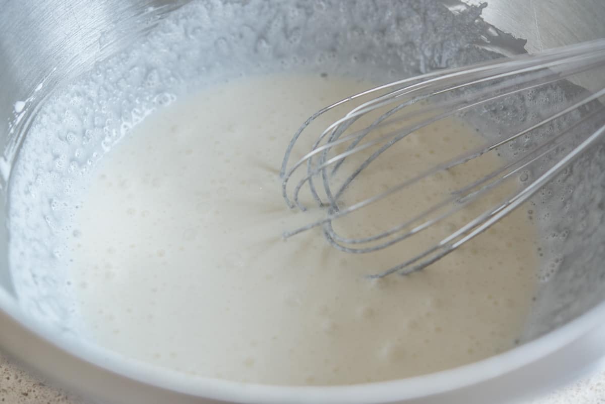 Whisking the cream together, with frothy bubbles on the surface